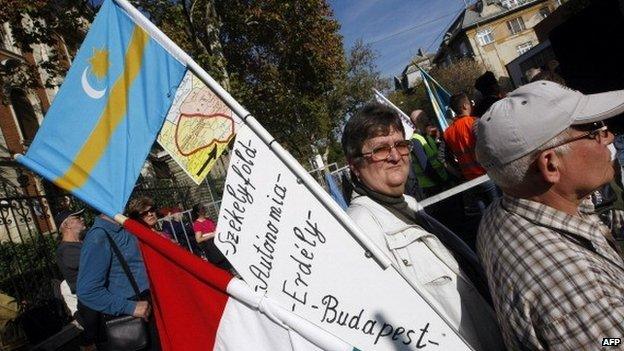 Hungarians hold Hungarian and Transylvanian flags as part of a protest in 2013