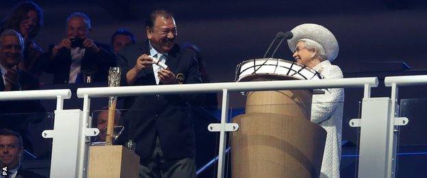 Prince Imran laughs after struggling to open the baton as The queen looks on