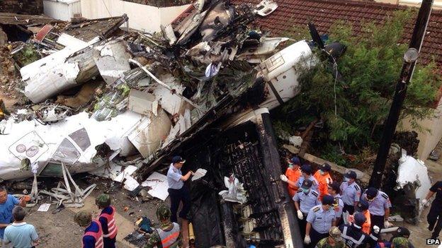 Police and soldiers guard the crash site of the TransAasia Airways plane on the Penghu Islands in the Taiwan Strait on 24 July 2014