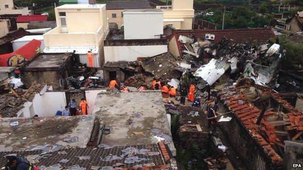 Police and soldiers guard the crash site of the TransAsia Airways plane on the Penghu Islands in the Taiwan Strait on 24 July 2014