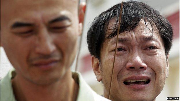 Relatives of passengers on board the crashed Transasia Airways plane cry on the Taiwan's offshore island Penghu, 24 July 2014.