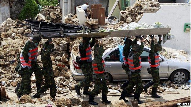 Soldiers remove the wreckage of TransAsia Airways flight GE222 on the Taiwan's offshore island Penghu, 24 July 2014.