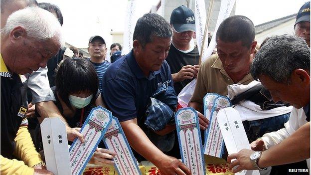 Relatives of passengers on board the crashed Transasia Airways plane prepare for a Daoist ceremony on the Taiwan's offshore island Penghu, 24 July 2014