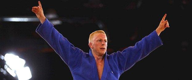 James Millar of Scotland celebrates victory in the mens - 66kg bronze medal contest