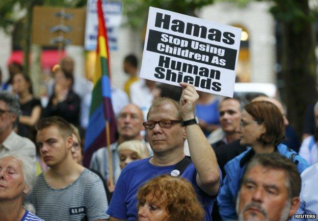 A pro-Israel supporter holds a placard reading "Hamas stop using children as human shields" during a rally in Berlin - 25 July 2014