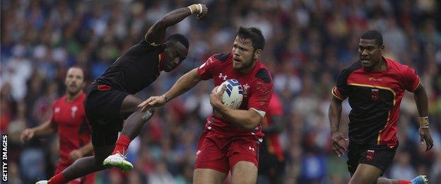 Adam Thomas of Wales breaks the Papu New Guinea defence during their rugby sevens match at the 2014 Commonwealth Games