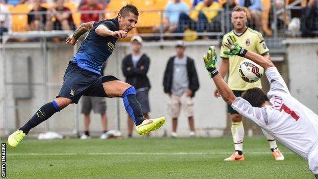 Stevan Jovetic scores past AC Milan goalkeeper Michael Agazzi