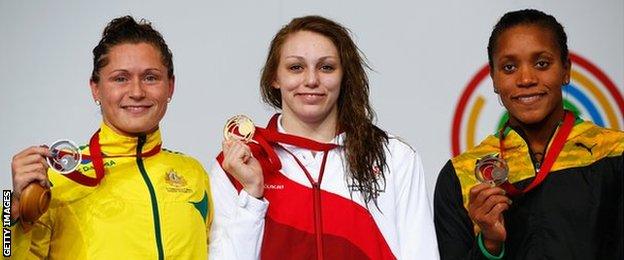 Sophie Taylor of England (centre) with her gold medal alongside silver medallist, Australia's Lorna Tonks and Jamaica's Alia Atkinson with bronze