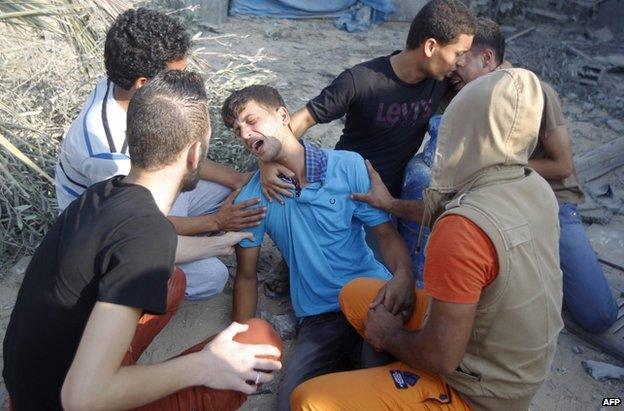 A Palestinian youth grieves for people killed in Rafah, in the south of the Gaza Strip, 29 July