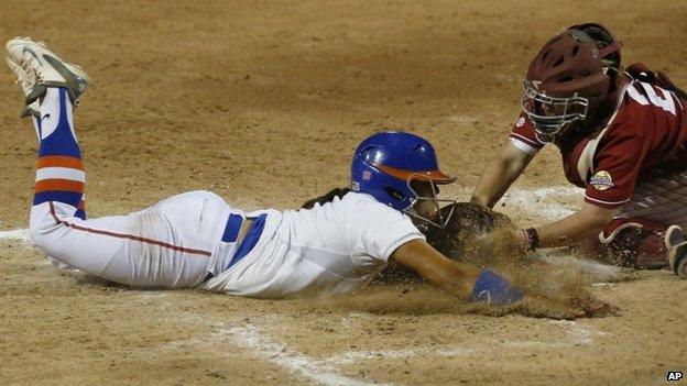 Alabama catcher Molly Fichtner (22) tags out Florida's Stephanie Tofft, left, at home plate in the sixth inning of an NCAA Women's College World Series softball tournament game in Oklahoma City, 3 June 2014