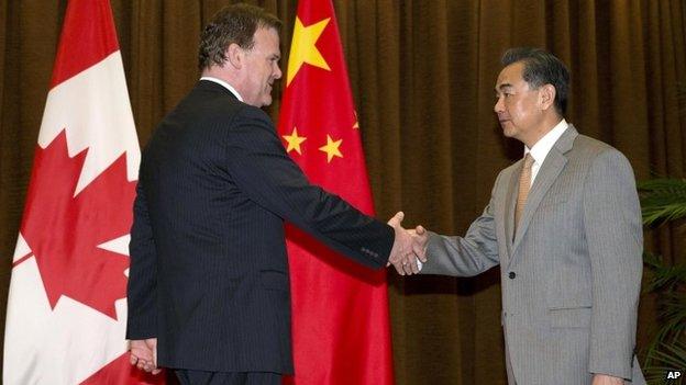 Canada’s Foreign Minister John Baird, left, shakes hands with Chinese Foreign Minister Wang Yi before a meeting at the Foreign Ministry in Beijing, China, 29 July 2014