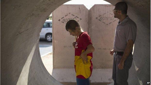 Israelis take cover as a siren warning of incoming rockets sounds in the southern city of Ashkelon on 28 July 2014.