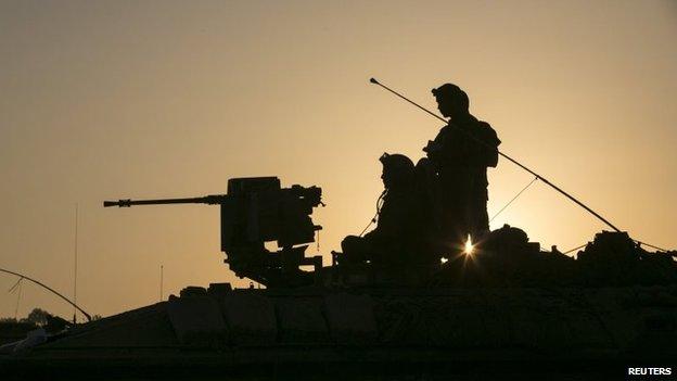 Israeli soldiers are seen atop an armoured personnel carrier (APC) near the border with Gaza July 30