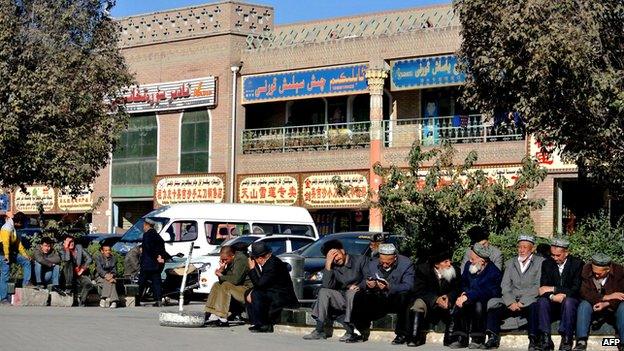 This picture taken on 8 November 2013 shows a group of Uighur men sitting by a street in Kashgar, farwest China's Xinjiang region.