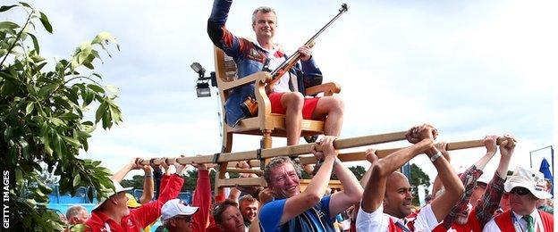 David Luckman carried after winning shooting gold