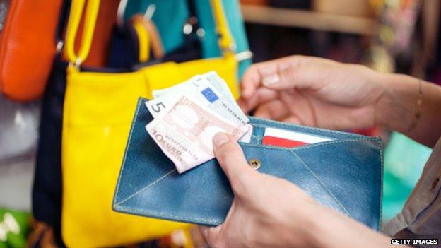 Young woman buying handbag in Florence Italy