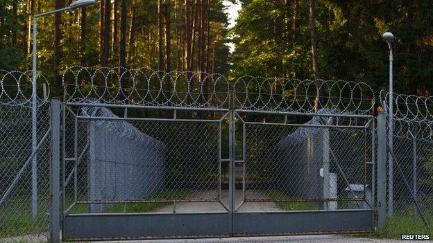 A barbed wire fence surrounding a military area is pictured in the forest in Stare Kiejkuty village in northeastern Poland, 16 August 2013