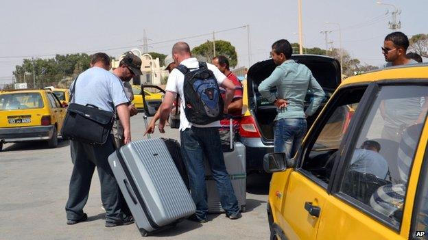 Tunisian taxi drivers wait for clients fleeing from Libya at the Ras Ajdir border post between Libya and Tunisia (31 July 2014)