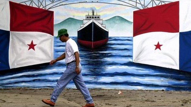 man walking past mural of panama flag