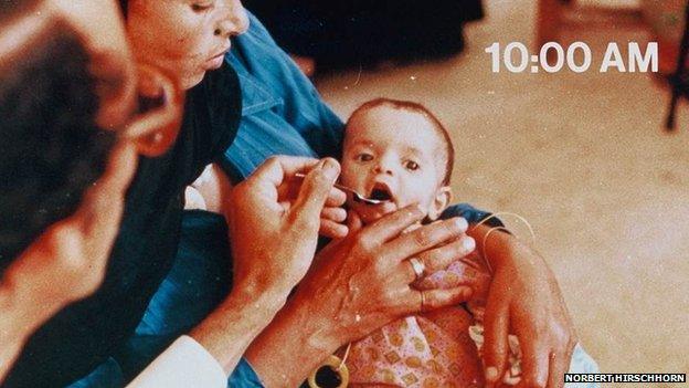 baby being fed solution with spoon at 10am, looking healthier