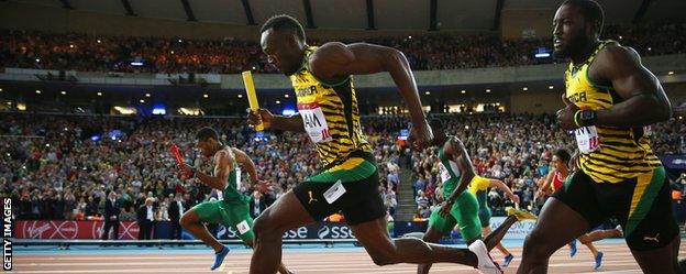 Usain Bolt takes the baton in the 4x100m relay heat at the Commonwealth Games