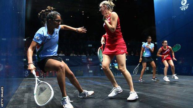 Dipika Pallikal of India is blocked by Laura Massaro of England during the Squash Women's Doubles Final between England and India