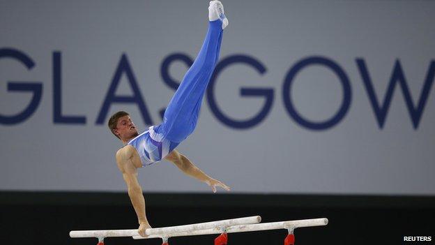 Frank Baines of Scotland performs on the parallel bars during the men's gymnastics team final