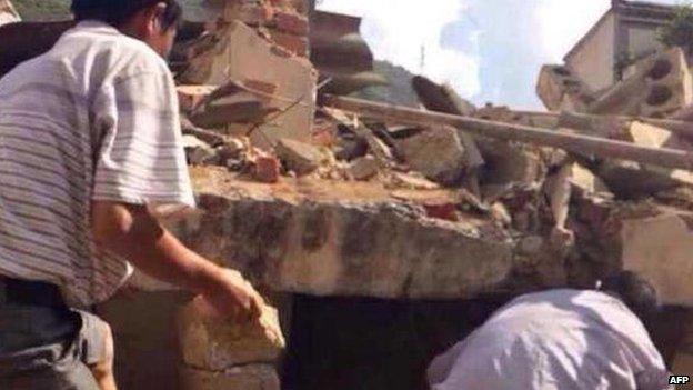 Rescuers work in rubble in Zhaotong, 3 Aug