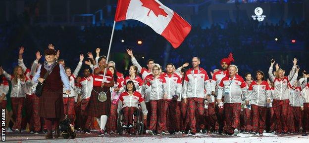 Susan Nattras carries the Canadian flag at the opening ceremony