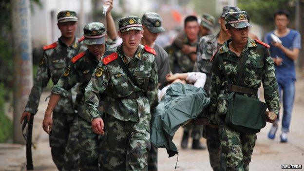 Paramilitary policemen carry an injured resident on a stretcher after an earthquake hit Ludian county of Zhaotong, Yunnan province August 3, 2014