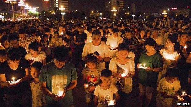 Residents gather as they attend a candlelight vigil for victims of a factory explosion, in Kunshan, Jiangsu province 2 August 2014