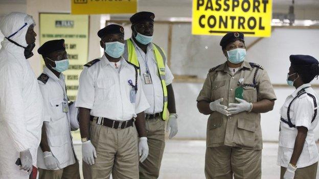 Nigeria health officials wait to screen passengers at the arrival hall of Murtala Muhammed International Airport in Lagos, Nigeria, Monday, 4 August 2014