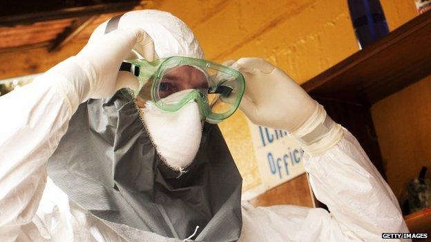 A person in a protective suit works at an Ebola isolation ward at a mission hospital outside of Monrovia, Liberia (4 August 2014)