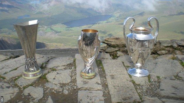 The Uefa Champions League, Europa League and Super Cup trophies were taken to the top of Snowdon to mark the staging of the Super Cup final in Cardiff on 12 August