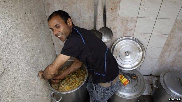 Afghan migrant Rahman Jan Safi prepares a meal for asylum seekers in Calais, northern France