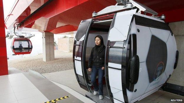 A passenger leaves a cable car decorated to look like a football on 24 June 2014.