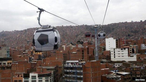 Cable cars decorated to look like soccer balls are pictured over La Paz on 24 June, 2014.