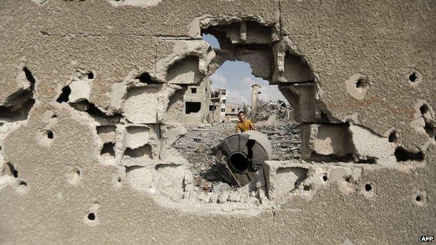 A Palestinian inspects destroyed houses and the area where the Al-Wafaa hospital used to stand in the Al-Shejaea neighbourhood of Gaza City