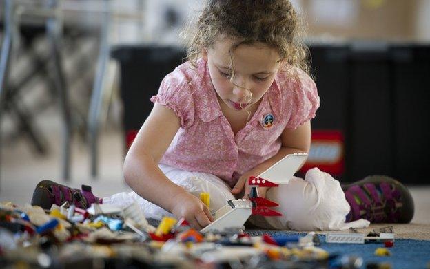 A girl plays with Lego