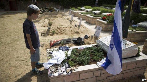 A young Israeli attends the grave of a soldier killed in the Gaza fighting, 5 Aug