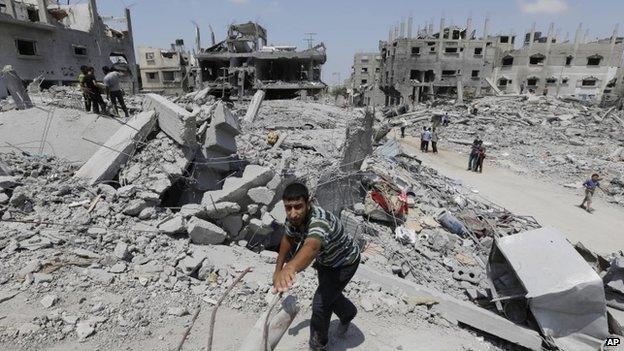 A Palestinian walks on rubble