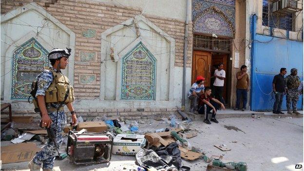 Iraqi security forces and civilians inspect the site of a suicide attack at a mosque in the Shorja market area in central Baghdad