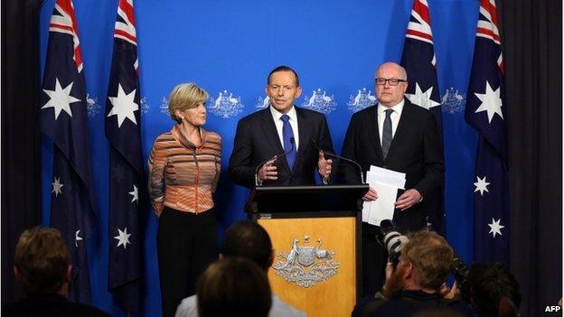 This picture released by the Australia Prime Minister Office on 5 August 2014 shows Prime Minister Tony Abbott (centre) speaking at a joint press conference with Foreign Minister Julie Bishop and Attorney General George Brandis (right) in Canberra