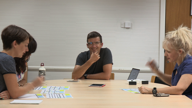 William in a meeting. There are three other people at the desk and lots of notes