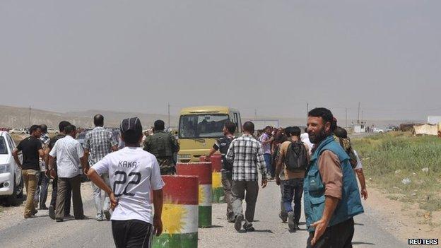 Yazidi families, on the outskirts of Sinjar, flee fighting between Peshmerga and Islamic State fighters (5 August 2014)