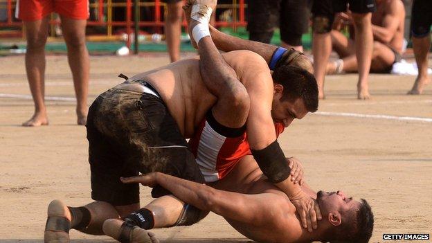 A Danish kabaddi player (top) is tackled by his Canadian opponent during the 4th World Cup Kabaddi Punjab 2013 tournament