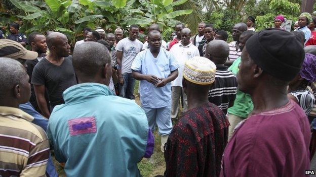 A Liberian nurse (C) addresses family members of dead Ebola victims before burial on the outskirts of Monrovia (6 August 2014)