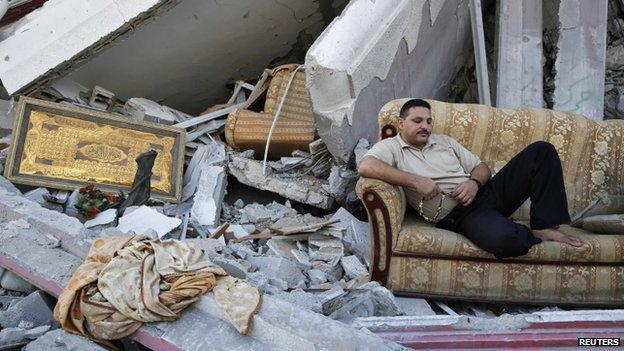 A Palestinian sits amid the ruins of destroyed homes in the Shejaia neighbourhood in Gaza City (6 August 2014)