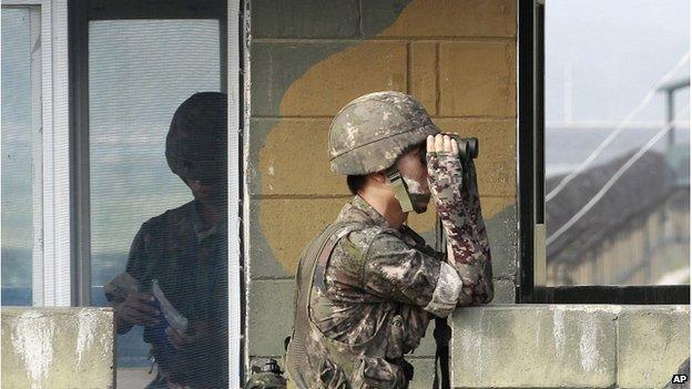 A South Korean army soldier looks through a pair of binoculars at a military check point at the Imjingak Pavilion near the border with North Korea, South Korea, Sunday, 13 July 2014.