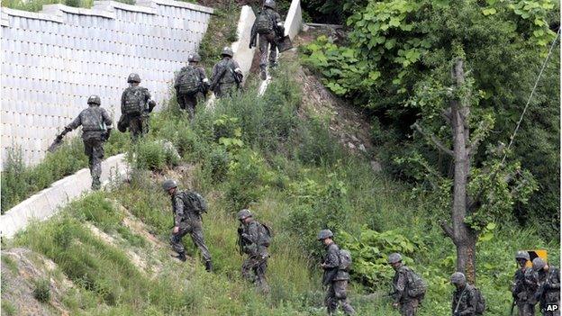 South Korean army soldiers head to search for a South Korean conscript soldier who is on the run after a shooting incident in Goseong, South Korea, Sunday, 22 June 2014